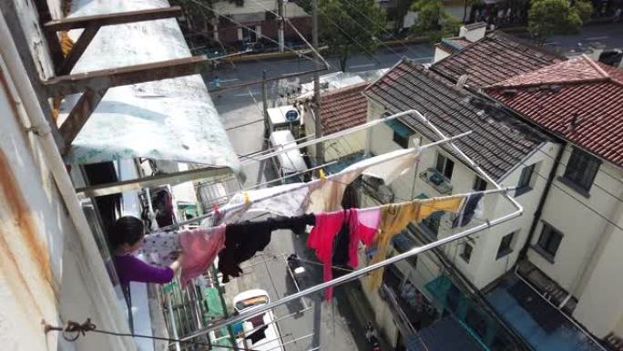 中国妇女将洗过的衣服挂在窗户上晾干，中国上海
