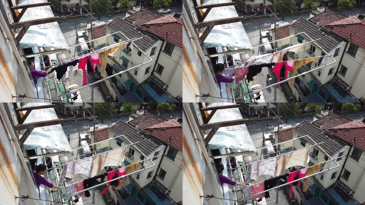 中国妇女将洗过的衣服挂在窗户上晾干，中国上海