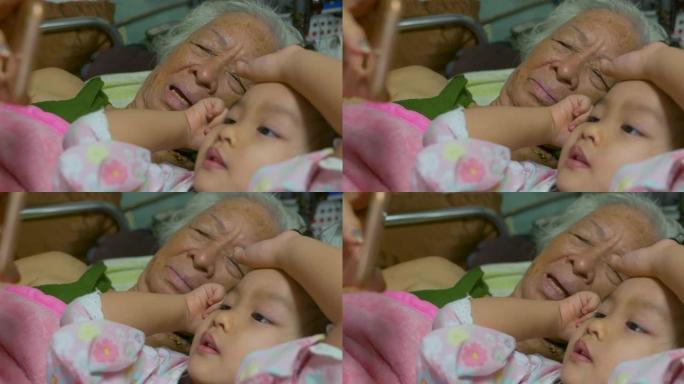 快乐的亚洲祖母和孙女在床上聊天很开心。
