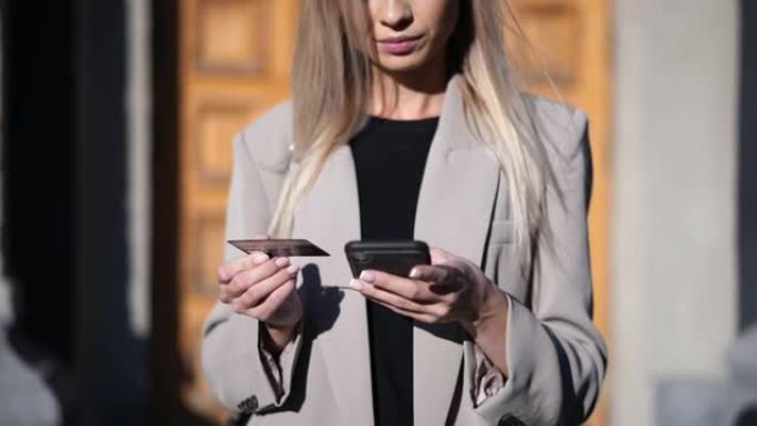 女性使用智能手机通过信用卡付款进行在线购物