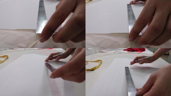 有尺子的女裁缝用铅笔在纸上画一个图案。