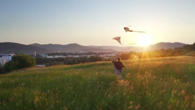 4k母女在放风筝的高高的草丛中奔跑，背景为落日