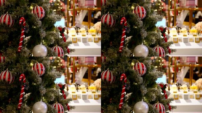 带有白色和红色球的圣诞树在现代购物中心与顾客