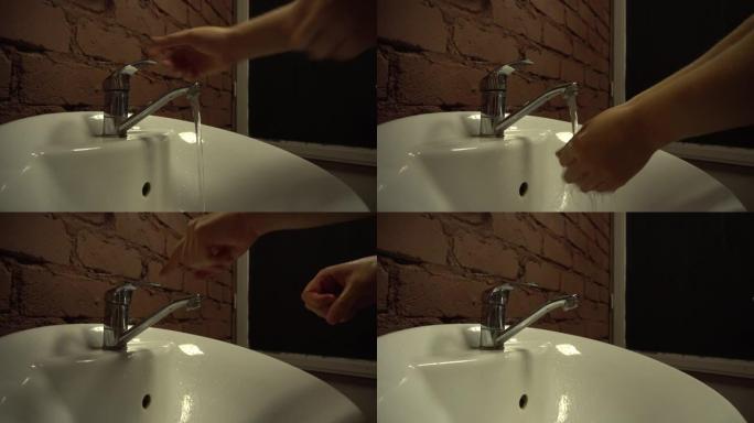 洗脸盆在一家餐馆里，一个家伙在洗脸盆里洗手，洗脸盆里光线昏暗，在时髦的咖啡馆里洗手，在水槽里洗手