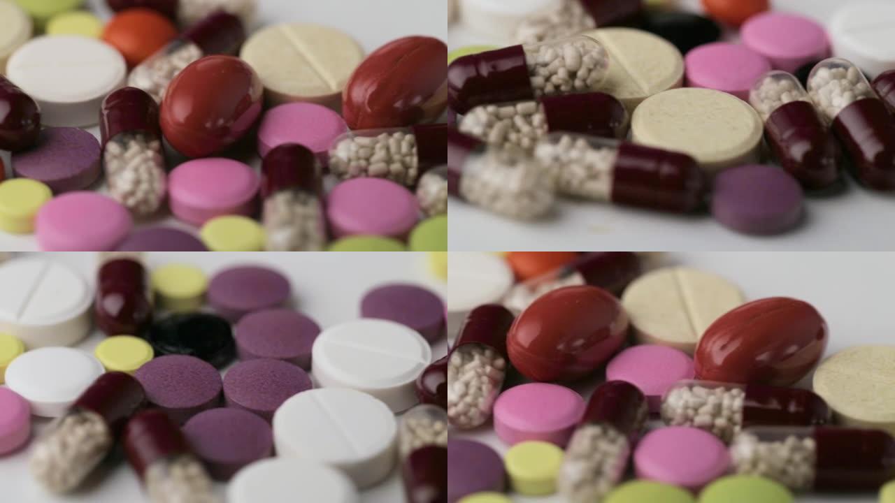 医学概念。多色药物背景。不同颜色的补救措施，药丸，抗生素和维生素旋转在白色背景特写。