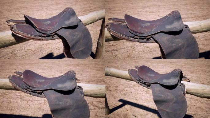 一个古老的老式皮革马鞍放在木马挂杆上