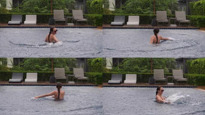 大雨时在游泳池里洗澡，女人享受假期