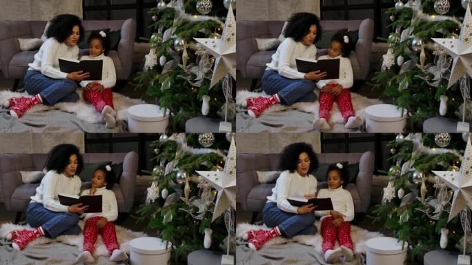 一个快乐的非洲裔美国妈妈给她的小女儿读童话故事的肖像。女人和女孩坐在沙发和装饰圣诞树附近。家庭之夜快