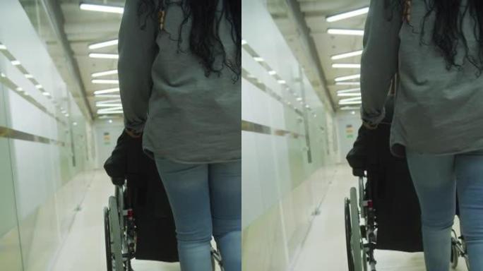 一位年轻女士正坐着轮椅开车穿过办公室