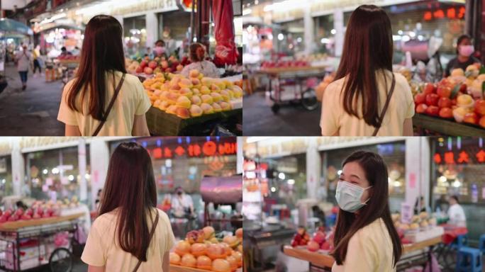 一位年轻的亚洲妇女在曼谷唐人街区寻找famaus街头食品的肖像。她穿着休闲的街头风格服装，喜欢吃货