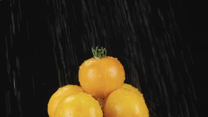 慢动作。雨滴落在一堆黄色番茄上。蔬菜金字塔。