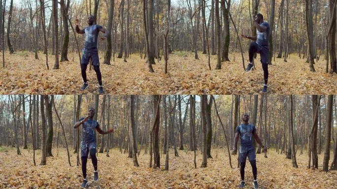 一个成年的黑皮肤男子在高大树木的背景下体操。运动服。体育用品商店的概念。秋季。
