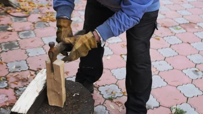 一个欧洲农民的手正在用铁斧砍柴。慢动作