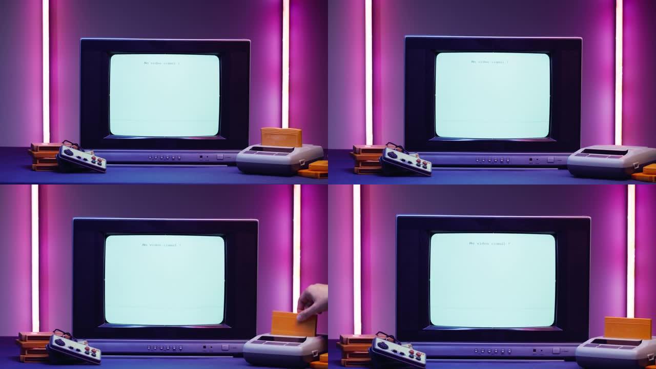 紫色霓虹灯背景上带有蓝屏的旧电视。老式电视和复古playstation的特写镜头，更换墨盒。古董视频