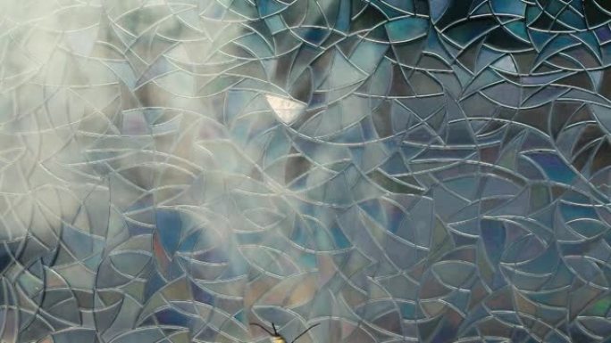 深色彩色玻璃上的纸风筝蝴蝶