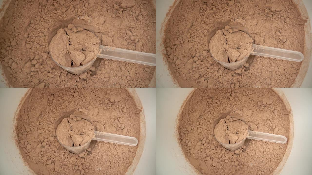 在水箱中拍摄极端微距，从装有巧克力蛋白粉的量杯移开。顶视图。