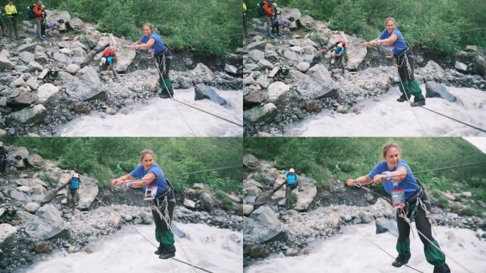 一名游客使用垂直绳索过河，并用登山扣固定