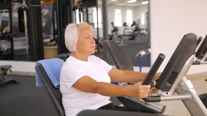 康复中心健身房，从受伤和骨折中恢复。老年妇女在模拟器上进行锻炼。健康的生活方式，概念高级，养老金领取