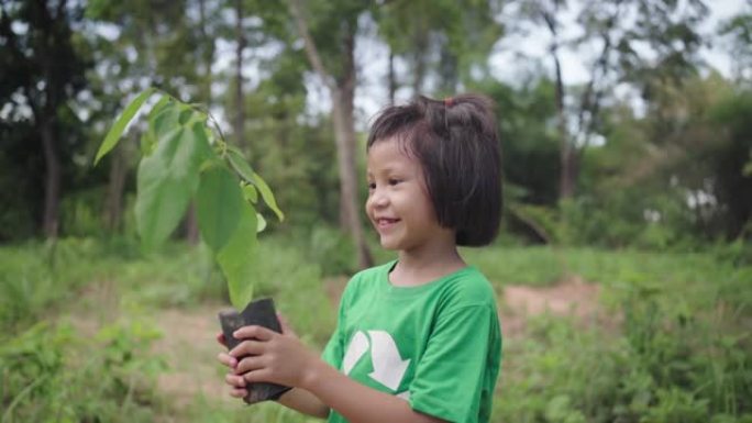 小孩子在森林里种树。地球日。