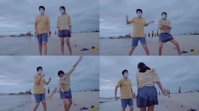 亚洲儿童戴着口罩，并在清晨一起在海滩上跳舞，这是新的正常生活方式概念。