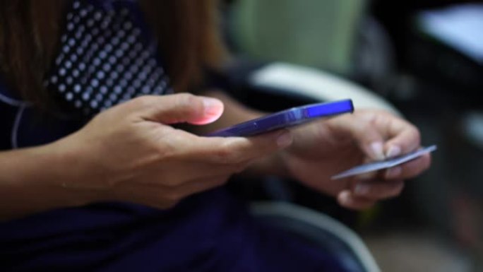 一名妇女使用智能手机登录以在线验证其身份。