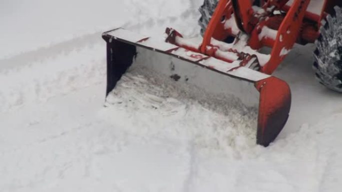 带有黄色桶的装载机在冬天清除道路并清除积雪。除雪设备