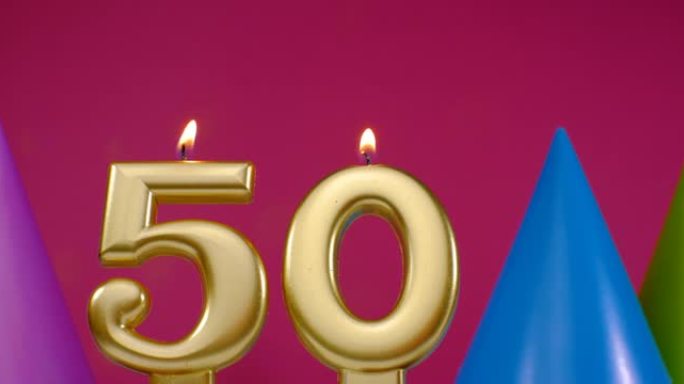 燃烧生日蛋糕蜡烛50号。生日快乐背景周年庆典概念。