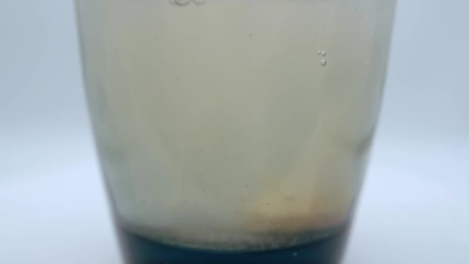 白色背景上的模糊圆形泡腾片溶解在水中，维生素或抗氧剂药片溶解在水中给人活力和良好的感觉