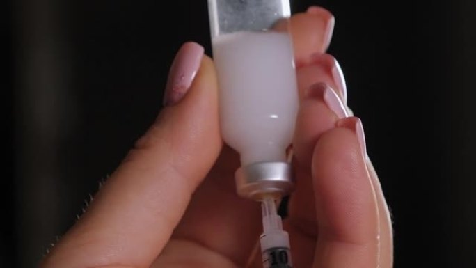 患有糖尿病的妇女用注射器和胰岛素在手边特写。糖尿病概念。
