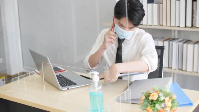 新常态办公室生活，年轻人工作时戴口罩和玻璃墙预防病毒