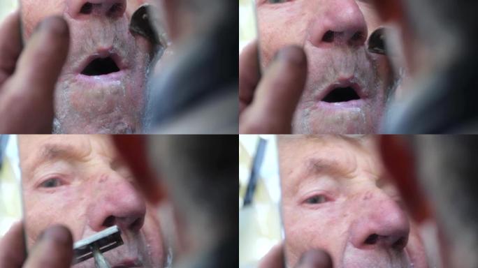 一位老人在镜子前剃了脸。养老金领取者剃掉了胡须。