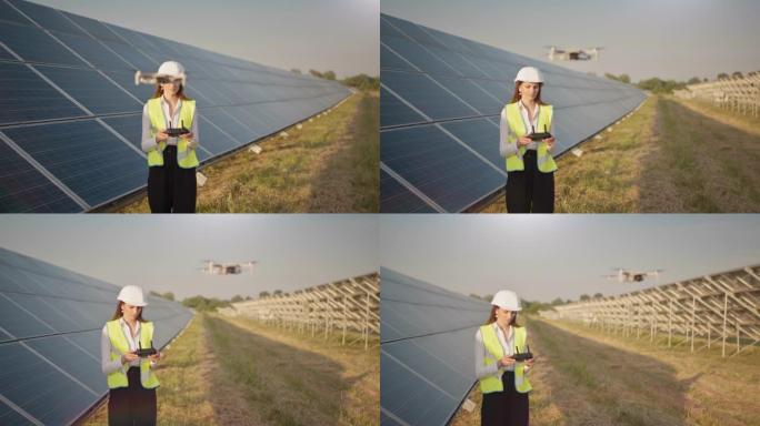 戴着安全帽的女工程师拿着平板电脑在太阳能发电厂操作无人机。光伏太阳能电池板安装。太阳能电池阵列。新技