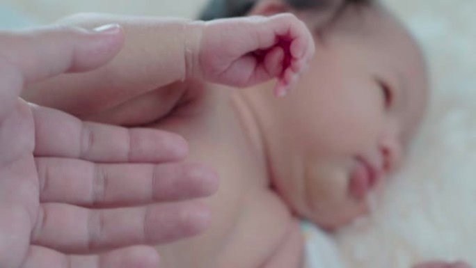 新生婴儿手握着母亲手指的特写镜头