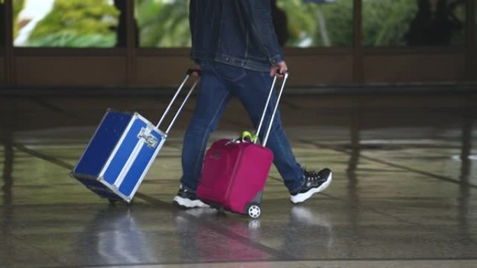 步行游客携带蓝色装甲防护钢手提箱，带粉色包。