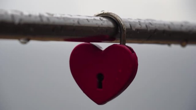 桥梁金属栏杆上的红色心形挂锁。公园里的爱情锁-永恒的爱情，友谊和浪漫的象征