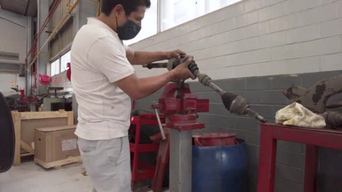 拉丁美洲男性技术员在墨西哥拉丁美洲的车间站车库中固定汽车的驱动轴