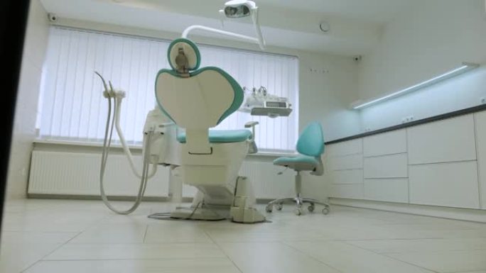 现代牙科诊所。牙科用的椅子和其他配件由牙医在蓝色，军医灯。
