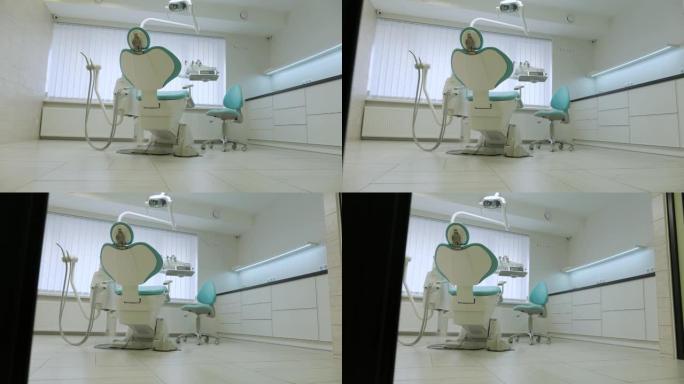 现代牙科诊所。牙科用的椅子和其他配件由牙医在蓝色，军医灯。