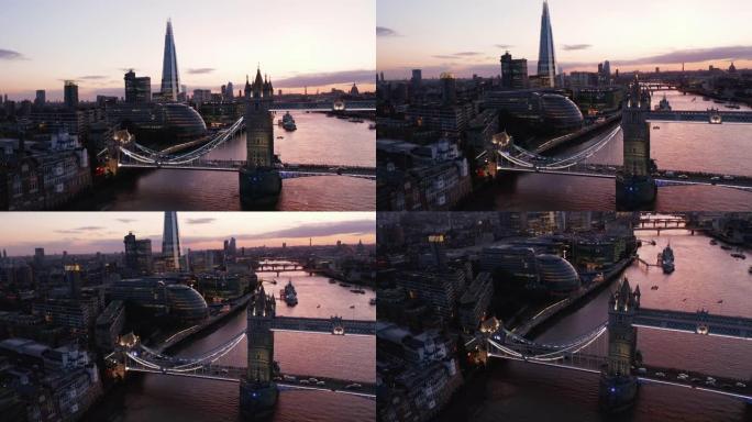 上升泰晤士河上塔桥的晚间镜头。市政厅和岸上碎片摩天大楼的现代建筑。水面反射粉红色的黄昏天空。英国伦敦