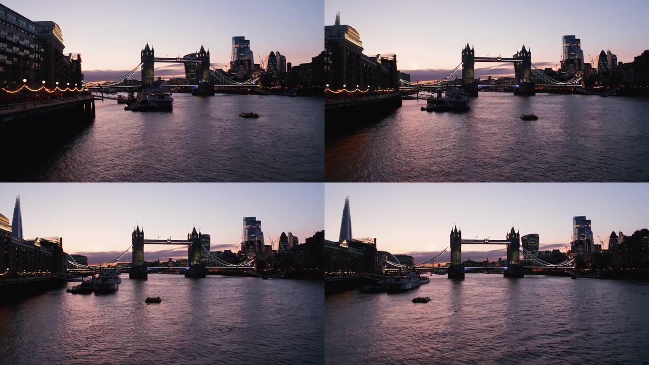 晚上，塔桥的幻灯片和平移镜头。巴特勒码头码头泰晤士河水上低空飞行。英国伦敦
