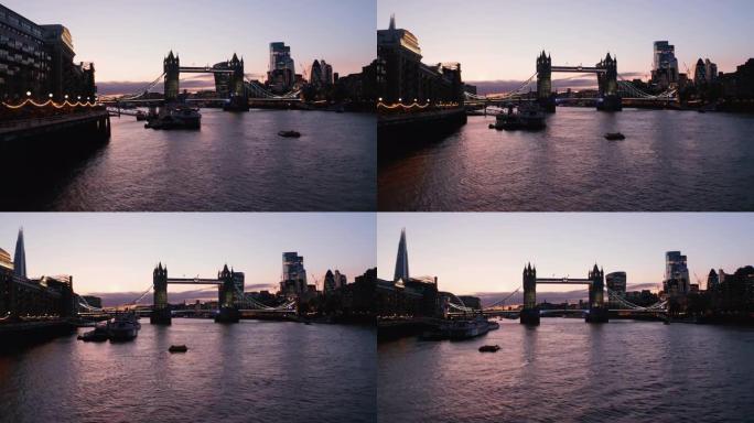 晚上，塔桥的幻灯片和平移镜头。巴特勒码头码头泰晤士河水上低空飞行。英国伦敦