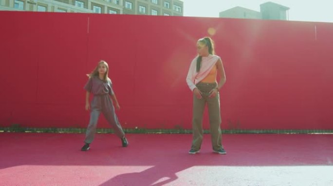 当代舞蹈学校广告视频。女舞者教青少年女童在阳光下跳舞。