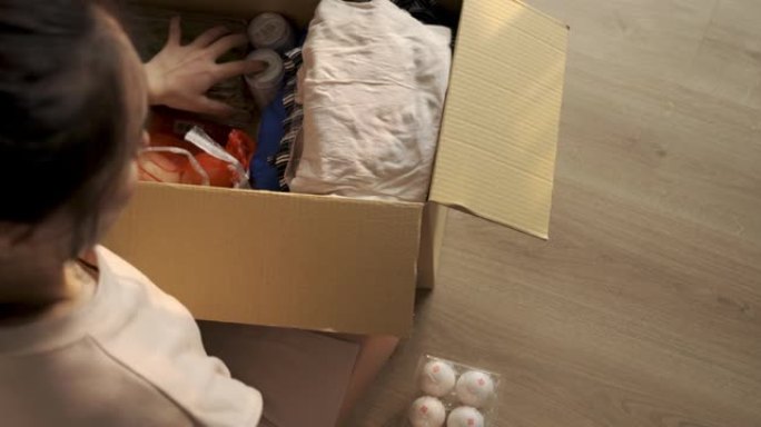亚洲女性志愿者将衣服和食物放在捐款箱中