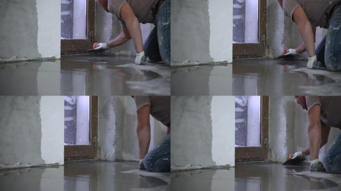 维修人员戴着防护手套和制服，使用金属刮刀对准液体自流平地板熨平板。工人在施工现场撒液体水泥溶液。新公
