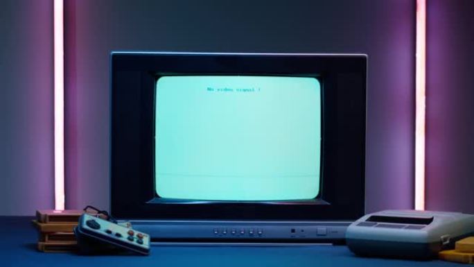 霓虹灯背景为蓝屏的旧电视。老式电视和复古playstation的特写镜头，更换墨盒。古董视频游戏，怀