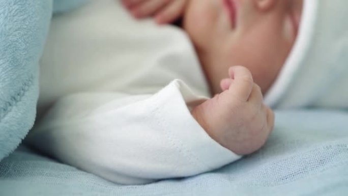 初生婴儿脸部肖像的特写镜头早年在白色蓝色背景上甜蜜地睡觉。孩子在帽子上生命的开始。婴儿，分娩，出生的