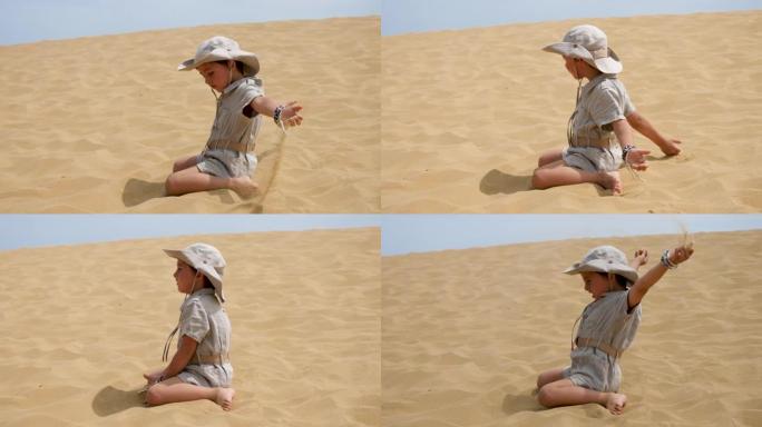 男孩正穿着旅行者的衣服坐在沙丘上