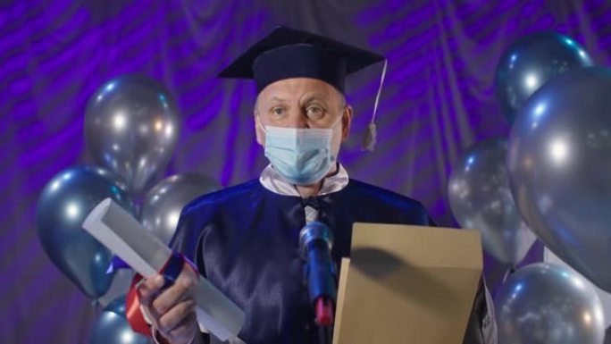 在线文凭，戴着医用口罩防止病毒和感染的快乐男性大学教授在停止学习期间通过视频链接和邮件向毕业生颁发培