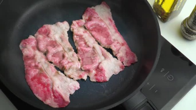 牛肉培根在平底锅中煎炸大理石薄牛肉