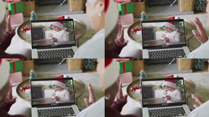 使用笔记本电脑与屏幕上的高加索男孩进行圣诞节视频通话的资深女性朋友